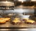 Plancha industrial profesional con hamburguesas smash en hamburguesería 2026