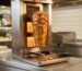 Asador de kebab döner profesional con cuchillo eléctrico de corte en local 2026