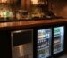 Equipamiento profesional de pub: botellero refrigerado y máquina de hielo en barra nocturna 2026