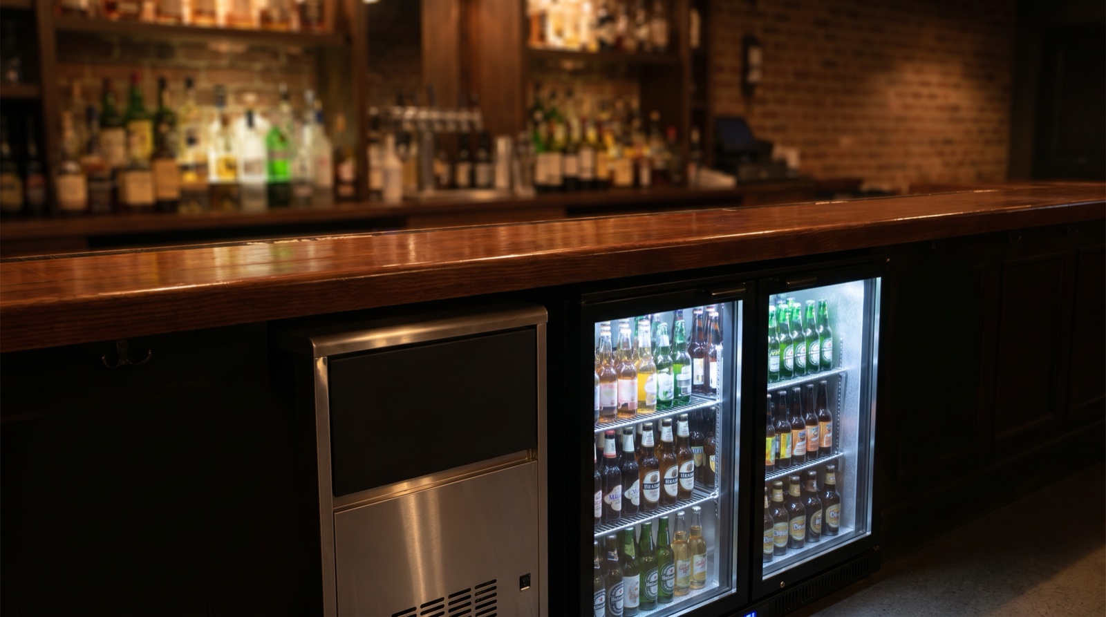 Equipamiento profesional de pub: botellero refrigerado y máquina de hielo en barra nocturna 2026
