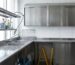 Zona de limpieza en hostelería: estanterías, fregaderos y armarios inox